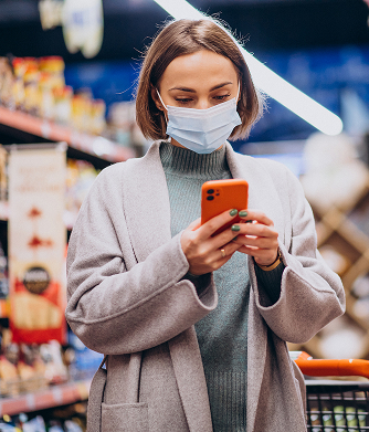 Shopper checking her phone in a retail store aisle